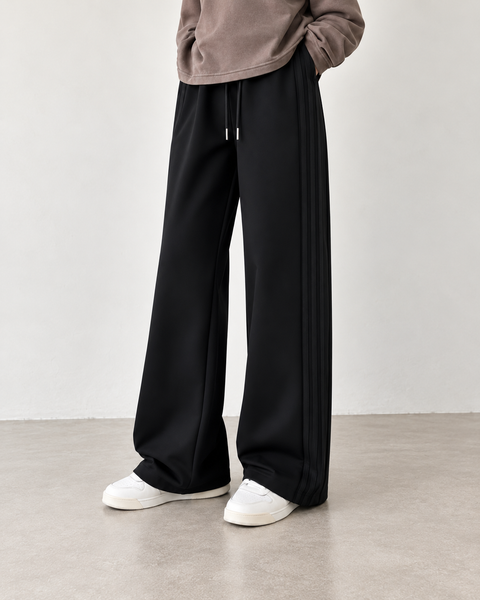 Black high-waisted side-seam wide-leg trousers — hero