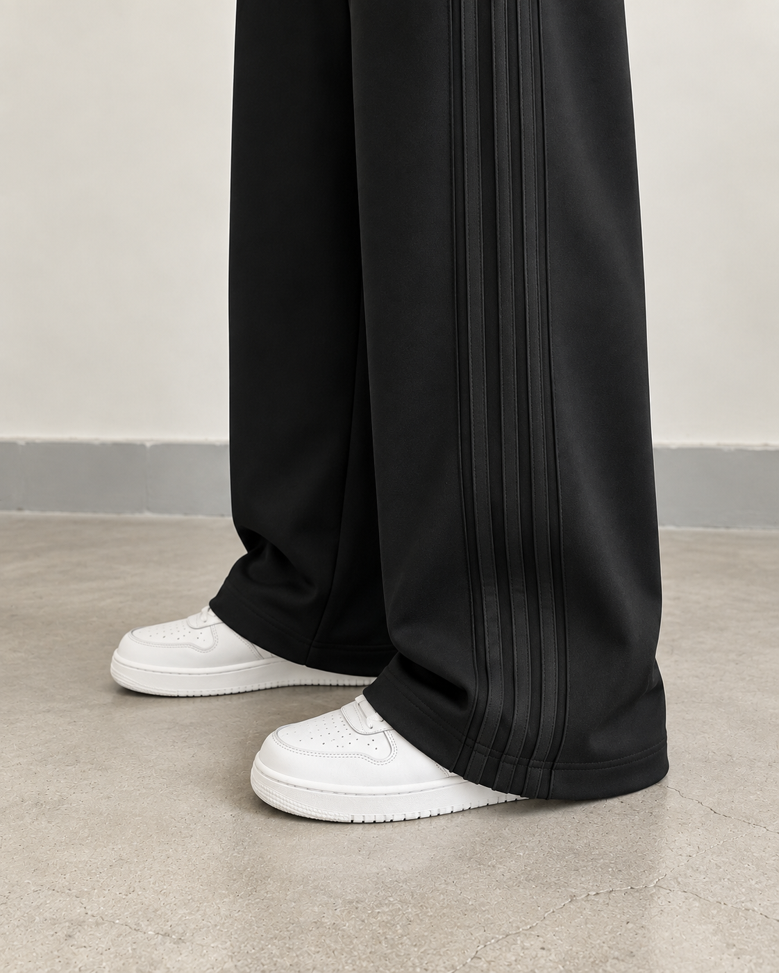 Black high-waisted side-seam wide-leg trousers — hem